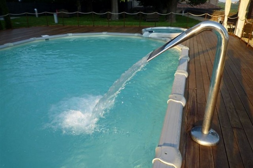 piscina fuori terra, particolare gioco d’acqua a cascata ed area con Deck in legno