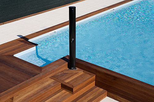 piscina interrata, particolare piscina a skimmer con scala laterale, doccia solare e pavimentazione in legno