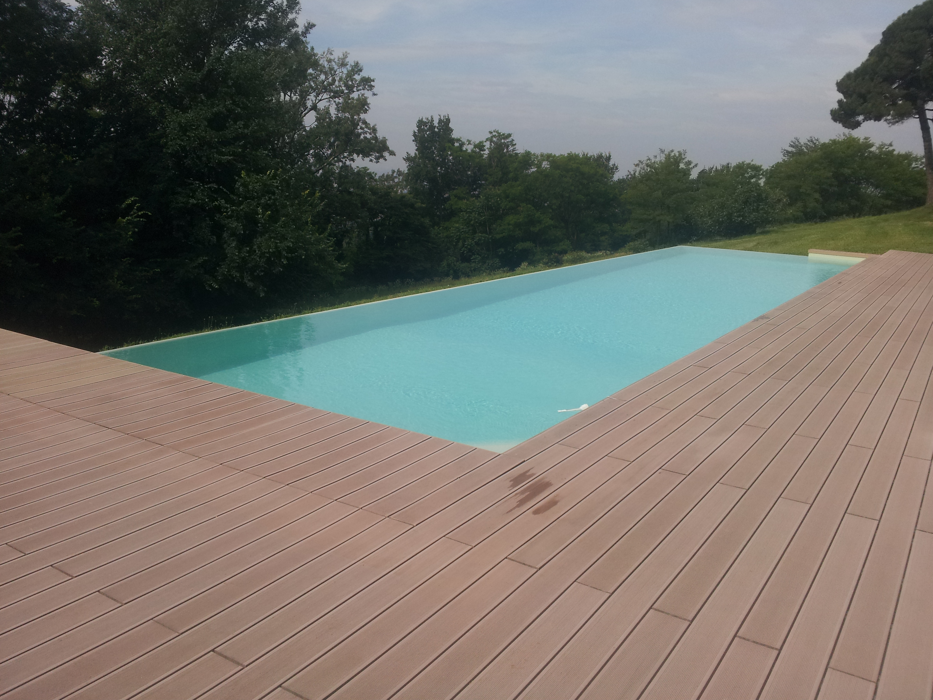 piscina infinity con deck in legno ricostruito