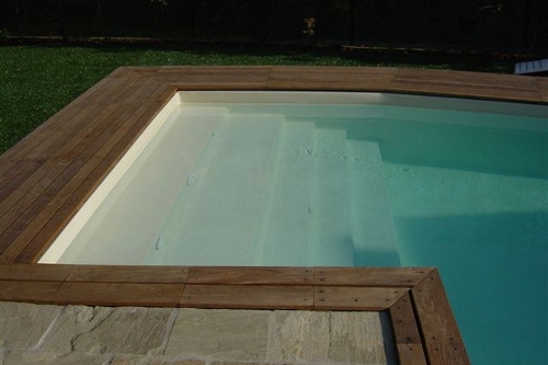 piscina interrata, particolare scala di accesso in opera con bordo in legno e pietra